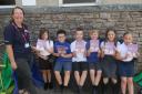 Amanda Walters from the Westmorland Dales Landscape Partnership Scheme distributing printed copies of Legends of the Westmorland Dales to children from Years 3.