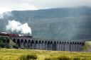 A steam train passes across the Ribblehead Viaduct