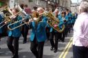 Sale Brass Band marching along Main Street, Kirkby Lonsdale, while taking part in the town's annual band contest.