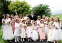 BRIDESMAIDS: Carly-Jade and Stephen Holland with their 19 bridesmaids