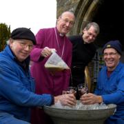TRADITION: Bathing a bell in beer at St Andrew’s Church, Dent. From left, Peter Scott, Bishop David Hope, the Rev Peter Boyles, and Neil Thomas