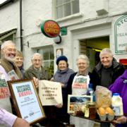 EVERYONE A WINNER: Chairman Robert Crompton (left) and Sheelagh Hughes-Hallett (right) at the head of a team of volunteers who have helped Storth Village Stores scoop a top award