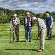 Geoff Hall on the practice putting green watched by (from left) Pat Hanson, Bob MacKeith and Phil Castle