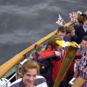 Torch bearer Stephanie Booth on the bow of the Tern on Windermere.