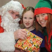 Madeleine King meets Santa and his helper at the school fayre