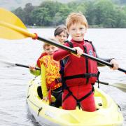 Theo Coates, Eddie Kelly and Karen Coates paddle to shore in an open kayak