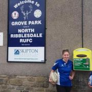 North Ribblesdale rugby players show off the new public access defibrillator at their Grove Park ground