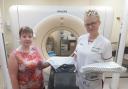 Treatment delivery team leader Kelly Littlefair (right) hands over the radiotherapy department’s stock of new Rosemere Cancer Foundation-funded gowns to treatment planning team leader Catherine Abbott