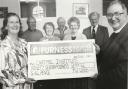 First Grange and Cartmel Scouts donated Â£97.64 from the proceeds of their coffee morning to the roof fund of the Cartmel Institute in 1997. Scout committee member Eunice Mullagh presents the cheque to Vicar of Cartmel Cannon Christopher