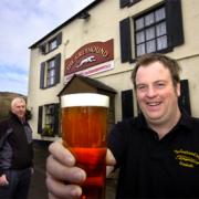MINE’S A PINT: Greyhound Inn management committee member Alan Irving raises a glass to the venture after the Greyhound was saved.